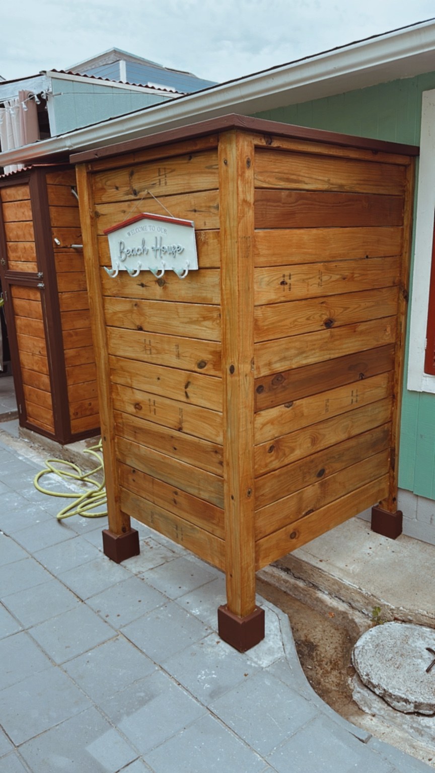 Finished custom exterior wood storage enclosure with stained boards and contrasting trim