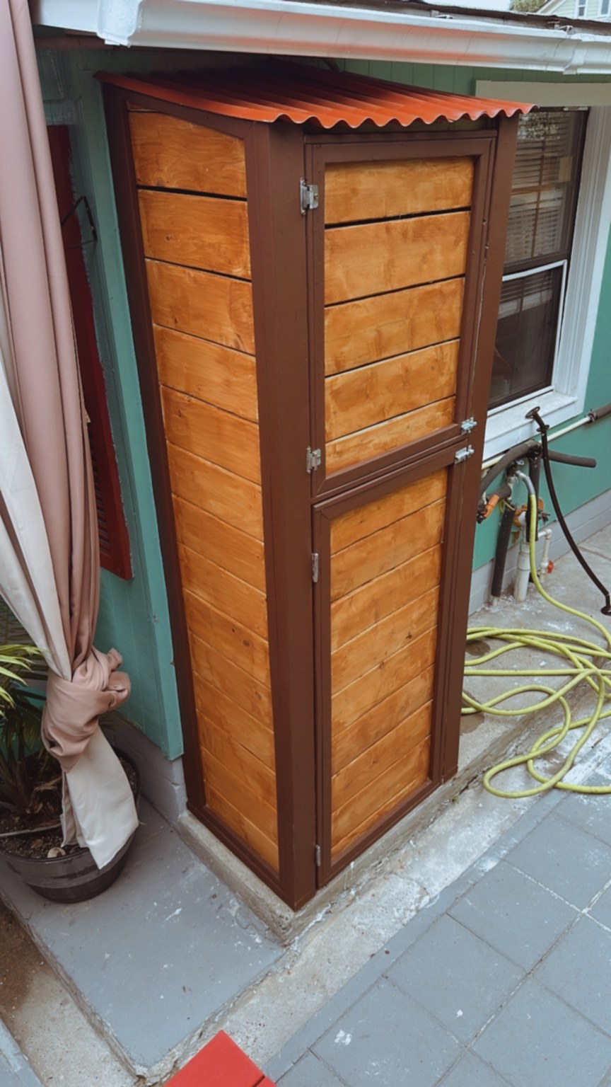 Finished custom outdoor storage cabinet with stained wood panels